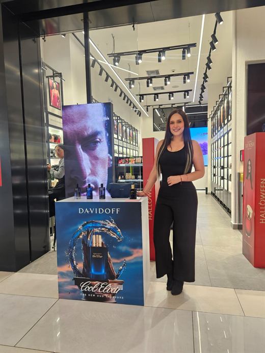 Promotora junto a material publicitario en centro comercial
