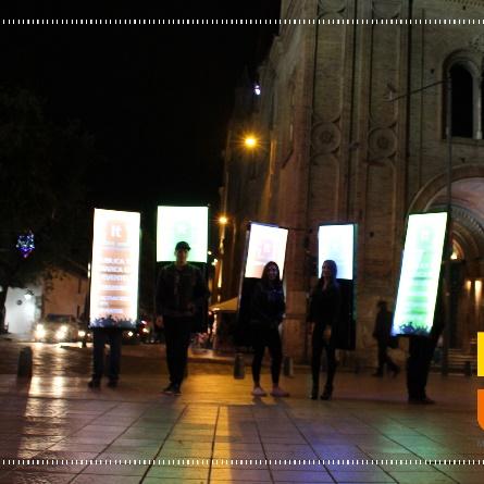 Mochilas publicitarias LED encendidas de noche en el centro histórico de Cuenca