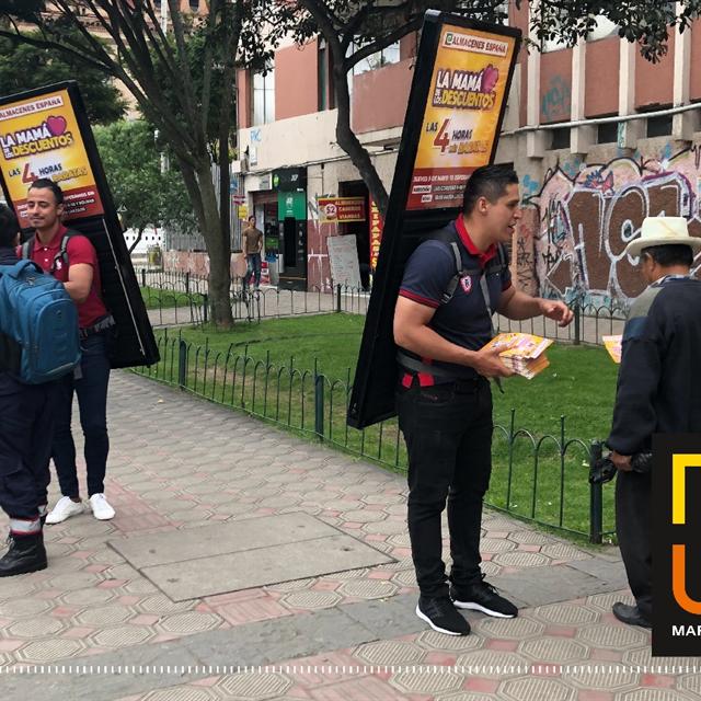 Equipo con mochilas publicitarias y volanteo en la vía pública